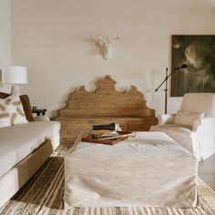 a living room with two couches and a coffee table in front of a deer head mounted on the wall