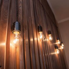 several light bulbs hanging from a wooden wall