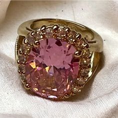 a pink diamond ring sitting on top of a white cloth