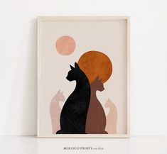 two cats sitting next to each other in front of a white wall with orange and pink circles