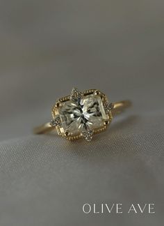 a yellow gold ring with an oval cut diamond in the center