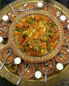 a plate filled with food on top of a table next to cups and spoons