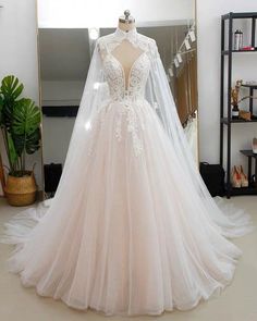 a wedding dress on display in front of a mirror with a mannequin behind it