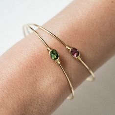 18 carat (750 thousandths) recycled gold bangle and green tourmaline in closed setting surrounded on both sides by a double ring, with lobster clasp.

 Gold weight: 3.35 g
 Tourmaline carat weight: 0.81 ct
 Diameter: 57.20 x 48 mm Classic Green Tourmaline Jewelry, 14k Gold Bracelet With May Birthstone, Adjustable Gemstone Bangle For Formal Occasions, Elegant Green Stackable Jewelry, Yellow Gold Round Tourmaline Jewelry, Gift Yellow Gold Tourmaline Jewelry, Elegant Gold Tourmaline Bracelets, Stackable Tourmaline Jewelry For Anniversary, Formal Yellow Gold Jewelry With Birthstone