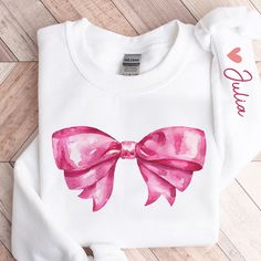 Introducing our Pink Bow Custom Name Sweatshirt - the perfect Valentine's Day gift and a trendy addition to your wardrobe. This stylish Ribbon Crewneck is not just a Valentine's Day sweatshirt; it's a cute and fashionable Ribbon Shirt that suits various occasions. This Women's Ribbon Tee, adorned with a charming Coquette Pink Bow, makes for an ideal birthday gift for the women you hold dear - be it your mom, sister, daughters, or friends. It's also a delightful choice for ballet enthusiasts, girl groups, and a thoughtful present for Christmas, National Women's Day, Thanksgiving, Mother's Day, or as a motivational and inspirational gift. Crafted with care, this Pink Bow Sweatshirt combines comfort and style, ensuring it becomes a wardrobe favorite. Whether you wear it for casual outings, co Spring Crew Neck Sweatshirt, Crew Neck Sweatshirt For Spring, Cute Graphic Print Sweatshirt For Gift, Spring Crew Neck Sweatshirt For Gift, Pink Letter Print Sweatshirt As Gift, White Crew Neck Sweatshirt For Gift, Cute Long Sleeve T-shirt As Gift, Pink Graphic Print Sweatshirt As Gift, White Crew Neck Sweatshirt As Gift