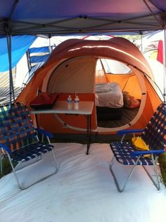 an orange tent with two chairs underneath it