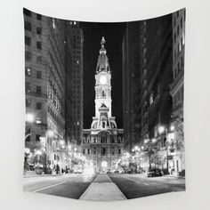 a black and white photo of a clock tower in the middle of a city at night