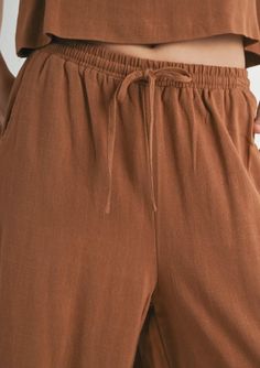 Featuring a relaxed fit with a comfortable elastic waistband, these pants provide a perfect, adjustable fit for all-day comfort. Dress them up for a casual brunch or down for a cozy night in. The Sugarloaf Elastic Waistband Pants in brown are versatile. Brown Relaxed Fit Bottoms For Leisure, Solid Straight Leg Harem Pants For Loungewear, Relaxed Bottoms With Drawstring For Fall, Relaxed Drawstring Bottoms For Fall, Comfortable Brown Leisure Bottoms, Comfortable Leisure Brown Bottoms, Casual Harem Pants With Pockets For Loungewear, Comfy Summer Bottoms With Pockets, Comfortable Fall Bottoms