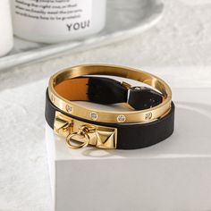 Sku: NSB1400GC-NSB1550STZD Details: Sleek and simple, this bracelet in leather with 14K gold plated. It is a statement-maker on its own or layered with other pieces. A great edition to an urban look or an informal outfit. This 14K gold/rose gold PVD bangle embellished with clear five of our best CZ stones. Arranged in an attractive and pleasing pattern, they catch the light from every angle. Our beautiful pieces are made of a metal that is hypo-allergenic which is great for those with sensitive Bracelet Stands, Womens Bangles, Jewelry Tags, Chic Leather, Urban Looks, Cz Stone, Black Handbags, Jewelry Designs, Active Wear For Women