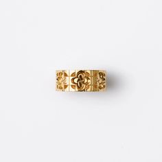 a gold ring with an intricate design on the front and side, against a white background