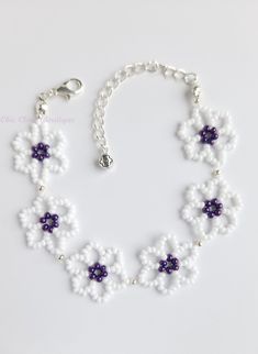 a white and purple beaded bracelet with flowers