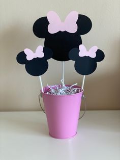 a pink bucket filled with marshmallows and minnie mouse toppers in front of a wall