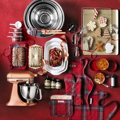 a red table topped with lots of different types of kitchen accessories and food items next to each other