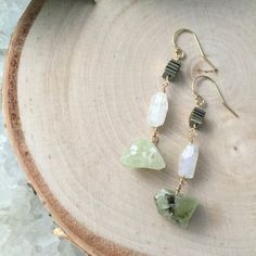 I have a weakness for raw stones and these raw chunks of Prehnite are no exception!  I think paired with the moonstone and gold beads, they are ridiculously gorgeous.  - Raw Prehnite- Moonstone Beads- Gold Fill, Gold Plated or Sterling Silver Ear wiresThese earrings will be ready to ship within 3-5 days. Your little beauties will arrive in a box, ready for gift giving. Please let me know if you would like a little note attached!Follow us on Instagram (@elevenandjane) and Facebook to see shop upd Bohemian Jade Gemstone Earrings, Natural Stone Jade Dangle Earrings, Green Spiritual Earrings With Natural Stones, Unique Jade Drop Earrings, Spiritual Green Earrings With Natural Stones, Everyday Green Earrings With Natural Stones, Handmade Dangle Earrings For May Birthstone, Spiritual Moonstone Earrings With Natural Stones, Green Moonstone Jewelry With Natural Stones