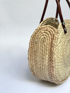 Sustainably Handwoven Straw Circle Bag The Mia Straw Circle Bag is lightweight and durable. This small-size bag will hold all of your essential items. It's the perfect bag for cruising around town. These bags are individually hand-woven with sustainable palm leaves and have naturally tanned leather handles. Thoughtfully designed and ethically made by artisans in Guerrero, Mexico, in a fair trade environment. Each bag is unique and may vary in size, and color, and may have small imperfections. De Everyday Crochet Bag With Open Weave, Eco-friendly Palm Leaf Bag With Open Weave, Eco-friendly Crochet Bag With Woven Leather, Natural Palm Leaf Beach Bag For Travel, Eco-friendly Woven Leather Bucket Bag, Natural Woven Leather Top Handle Bag, Luxury Rectangular Bucket Bag For Market, Eco-friendly Natural Color Woven Leather Shoulder Bag, Eco-friendly Natural Woven Leather Shoulder Bag