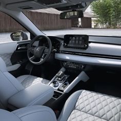 the interior of a car with all white leather seats and dashboard, including center console