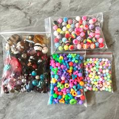 three bags filled with assorted beads on top of a counter next to each other