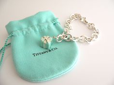 Overview: Here is a gift that she will surely adore! It is shiny, stylish, and super versatile! This piece will make someone REALLY happy! :) Offered for sale is a wonderful Tiffany & Co. Sterling Silver and Blue Enamel Signature Gift Box Bracelet. Hanging from its bright Tiffany silver chain is a very pretty Turquoise Gift Box charm! A classic Tiffany piece that any girl will adore! The Gift Box charm hangs from its Sterling Silver Tiffany clasp - it is removable from the bracelet and thus Designer Rectangular Bracelets As Gift, Luxury Rectangular Bracelet Gift, Elegant Jewelry Gift Ready For Birthday, Luxury Rectangular Bracelet As Gift, Elegant Birthday Gift Jewelry, Gift Ready, Elegant Birthday Gift-ready Jewelry, Elegant Jewelry For Birthday Gift, Rectangular Bracelet With Box Clasp For Gift, Rectangular Bracelet With Box Clasp As Gift