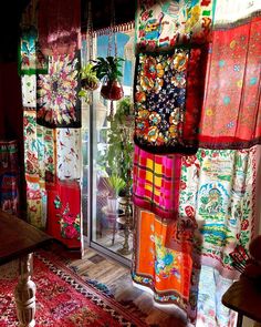 a room filled with lots of colorful rugs and windows covered in different colored fabrics