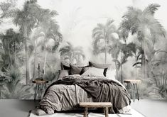 a bedroom with palm trees painted on the wall and bed in the foreground, along with two side tables