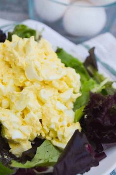 a white plate topped with salad and eggs