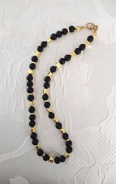 Collana con perle lisce di lava nere e barilotti in ematite  oro 18 k Gold Beaded Necklace With Black Onyx Beads, Elegant Black Jewelry With 8mm Beads, Gold Onyx Beaded Necklaces With Black Beads, Gold Onyx Beaded Necklace With Black Beads, Black Spiritual Jewelry For Party, Spiritual Black Jewelry For Party, Black Beaded Necklace With Gold Beads As Gift, Classic Gold Jewelry With Black Beads, Elegant Gold Onyx Beaded Necklaces