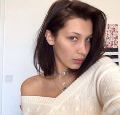 a woman in white sweater taking a selfie