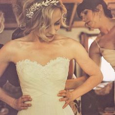 a woman in a wedding dress standing next to two other women