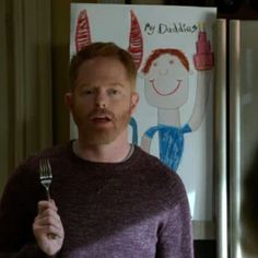 a man holding a fork in front of a poster