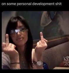 a woman wearing glasses making the middle finger sign