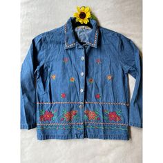 This vintage Bobbie Brooks denim jacket features vibrant embroidered floral patterns. Crafted from 100% cotton, it offers a unique, timeless style. * Button closure * Colorful floral embroidery * Long sleeves * Denim material * Made in Bangladesh * Exclusive of trimming Pit to pit = 21.5 inches Top to bottom = 24.5 inches Sleeve length = 17 inches Retro Embroidered Cotton Outerwear, Retro Cotton Outerwear With Embroidery, Long Sleeve Cotton Denim Jacket With Floral Print, Embroidered Cotton Button-up Outerwear, Floral Embroidered Cotton Button-up Outerwear, Bohemian Cotton Outerwear With Button Closure, Vintage Long Sleeve Denim Jacket With Floral Embroidery, Vintage Multicolor Embroidered Outerwear For Spring, Vintage Long Sleeve Denim Jacket For Spring