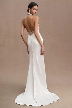 a woman wearing a white dress with an open back and beaded detail on the side