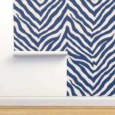 an animal print wallpaper with blue and white zebra stripes on the wall next to a roll of toilet paper