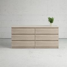 a wooden dresser with a potted plant on top