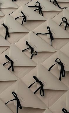 many pieces of paper with black ribbon tied around them on top of each other in rows