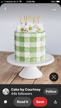 a green and white cake sitting on top of a table next to a cell phone