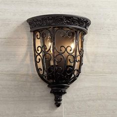 a wall light mounted on the side of a white brick wall in an old - fashioned style