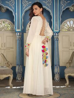 This is a beautiful single piece set. It comes with embroidery detailing anarkali style kurta has front round neck & back designer neck with dori & tassels, long sleeves & floor length. Total No of Set-1 Fabric: Cotton Work Done - Embroidery detailing. Kurta Length-Floor Length Sleeve Length: Long Sleeves Neck: Round Neck and Back Designer Neck with Dori & Tassels Style: Anarkali Color: White Occasion: Party Wear Washing Instructions: Hand Wash or Dry Clean White Long Sleeve Churidar For Party, Diwali Sharara With Tassels And Straight Kurta, Bohemian Long Sleeve Anarkali Set For Festive Occasions, Bohemian Long-sleeve Anarkali Set For Festive Occasions, Festive Long Sleeve Churidar With Mirror Work, Anarkali Style Sharara With Tassels For Festivals, Anarkali Traditional Wear With Tassels For Festive, Traditional Long Sleeve Salwar Kameez With Mirror Work, Diwali Anarkali Set With Straight Kurta And Tassels