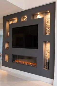 a large television mounted to the side of a wall with built - in fireplaces