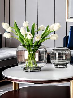 white tulips in a glass vase on a coffee table