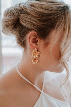 These oversized statement gold flower drop earrings are sure to steal the show, making them the perfect bridal accessory. We promise you'll want to wear these earrings again after your wedding day! If you're looking for one statement accessory for your big day, these earrings are it. Dimensions: Earrings are 5 cm long x 3 cm wide.  Our earrings, necklaces and bracelets are lead, nickel and cadmium free. These pieces are hypo-allergenic and are safe for sensitive skin and ears.  Each order is tho Gold Flower-shaped Wedding Earrings, Gold Bridal Drop Earrings With Flower Decoration, Gold Dangle Flower Earrings For Wedding, Gold Flower-shaped Bridal Earrings, Gold Bridal Earrings With Flower Decoration, Gold Earrings With Flower Decoration For Wedding, Rose Gold Flower Charm Earrings For Wedding, Gold Flower Wedding Earrings, Rose Gold Flower Wedding Earrings