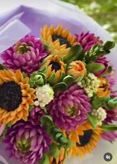 a bouquet of flowers sitting on top of a white table next to a purple box