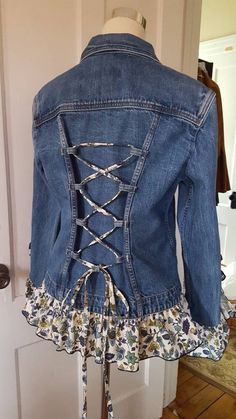 a denim jacket with floral print on the bottom and lace - up at the back