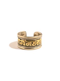 This adjustable ring is hand crafted by local artists of Nepal. It features the well known and oft chanted Tibetan holy mantra Om Mani Padme Hum artfully carved around the band, and a delicate rope like design decorating both sides. The brass ring can be gently pressed together to adjust to whichever finger on which you choose to wear it. Attractive and adjustable. Band measures almost 1/2 inch wide. Handcrafted in Nepal. Symbolic Adjustable Engraved Open Ring, Handmade Spiritual Toe Ring, Adjustable Ceremonial Toe Rings, Spiritual Promise Engraved Ring, Spiritual Engraved Promise Ring, Adjustable Engraved Open Ring Jewelry, Engraved Open Ring Jewelry, Handmade Symbolic Open Ring, Adjustable Engraved Spiritual Ring