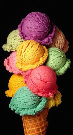 an ice cream cone filled with different colored ice creams on top of each other