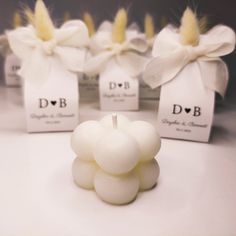 small white candles with bows on them sitting in front of tags that say d & b