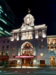 an old building lit up at night in the city