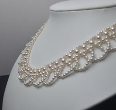 a white necklace with pearls on a mannequin