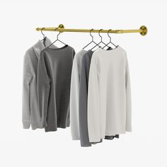 three sweaters hanging from a clothes rack on a hanger in front of a white background