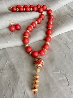 Coral Red Mountain Jade, 22 kt Gold Plated Beads, Coral 21" – Tru Original Designs Red Round Beads Mala As Gift, Red Round Beads Mala For Gift, Red Mala With Round Beads For Gift, Red Wooden Beads In Traditional Style, Red Wooden Beads Traditional Style, Red Traditional Wooden Beads, Festive Red Jewelry With Dangling Beads, Red Wooden Beads For Gift, Elegant Red Mala With Round Beads